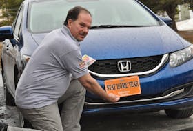 Dennis Blackwood of Blackwood Signs in Corner Brook holds up a 2020 Stay Home Year licence plate that he’s made on the front of his car.
Diane Crocker
