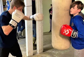 A couple of young boxers with the Westville Boxing Club, train on the heavy bag at the club's new location on Westville Road. 