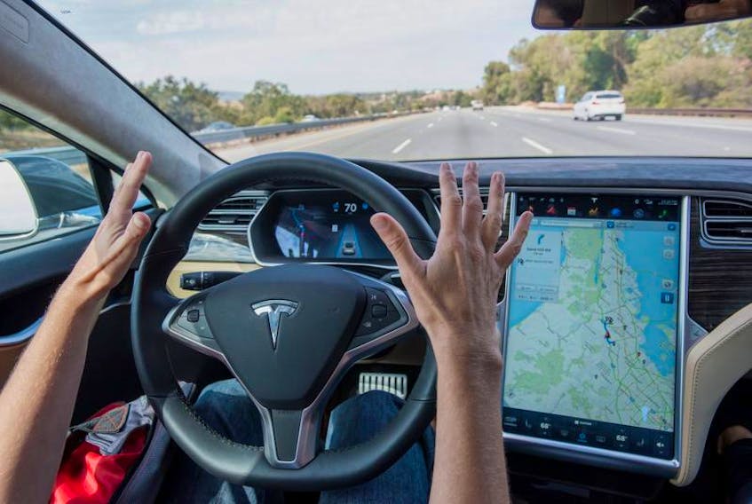 A member of the media test drives a Tesla Motors Inc. Model S equipped with Autopilot in Palo Alto, California.