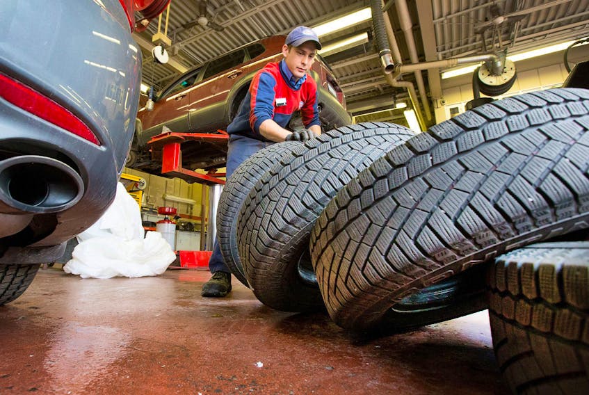 In this file photo, Charles Emsley from Island Park Esso in Ottawa balances and installs winter tires. Wayne Cuddington / Postmedia News 