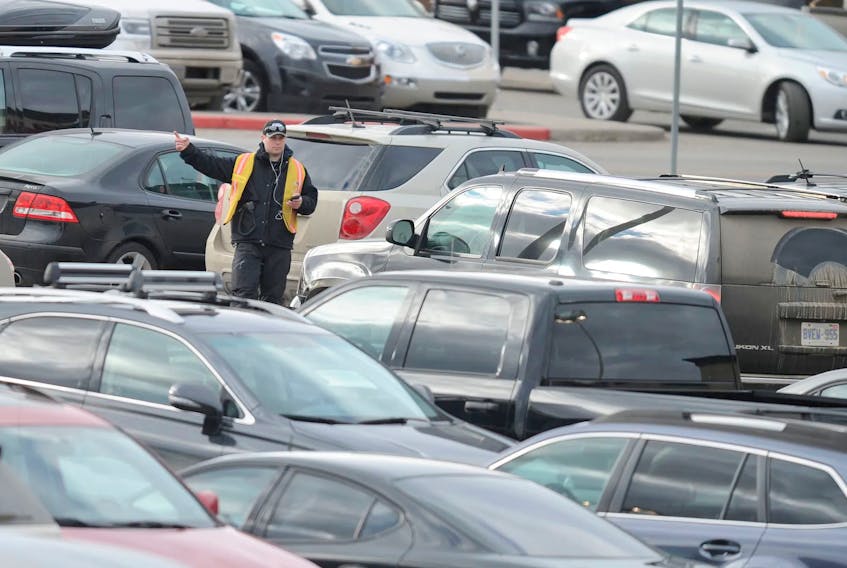 A lot attendant does his best to help park thousands of cars doing last-minute Christmas shopping at Chinook Centre in southwest Calgary.  Stuart Dryden/Postmedia Files