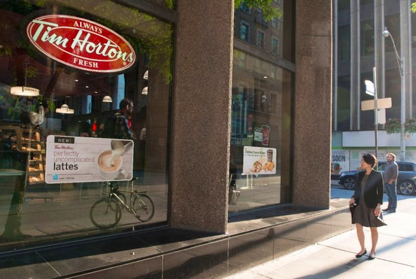 A woman walks pass a Tim Hortons in Toronto on Wednesday Aug. 2, 2017. Restaurant Brands International Inc. (TSX:QSR) says it has signed a deal with joint venture partner to take Tim Hortons to Spain. 