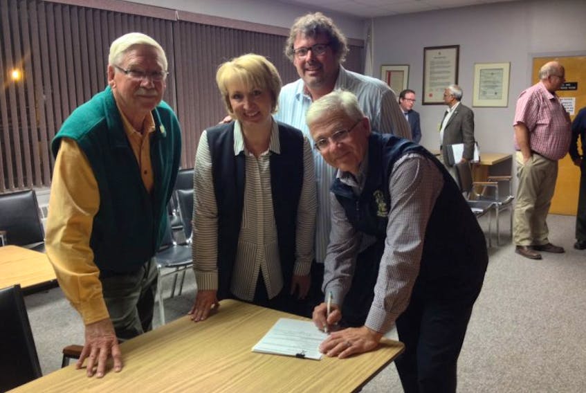 Members of Windsor Town Council, including Dave Seeley (left), Laurie Murley, Scott Geddes and Mayor Paul Beazley, sign a petition to amalgamate Windsor and the Municipality of West Hants.
