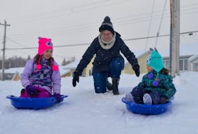 Ready, steady, go! Helped out by a push from grandmother Diane Hynes, sisters Gia Degiobbi, 7, left, and five-year-old Jenna begin their toboggan ride down a small hill near Sherwood Park Education Centre in Sydney’s south end on Tuesday afternoon. The girls were enjoying the snow, the relatively warm temperature and an extra week off from school. DAVID JALA • CAPE BRETON POST 