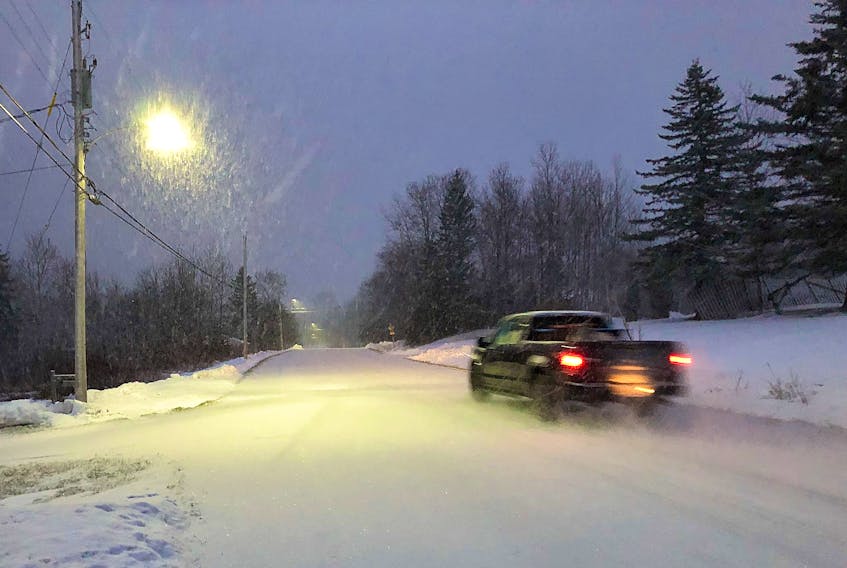 A truck drives alone the snowy road in Blacketts Lake as an early morning snowfall comes down. The dusting of snow didn't last long after the sun came out and temperatures rose to just above the average high for this time of year. NICOLE SULLIVAN/CAPE BRETON POST 