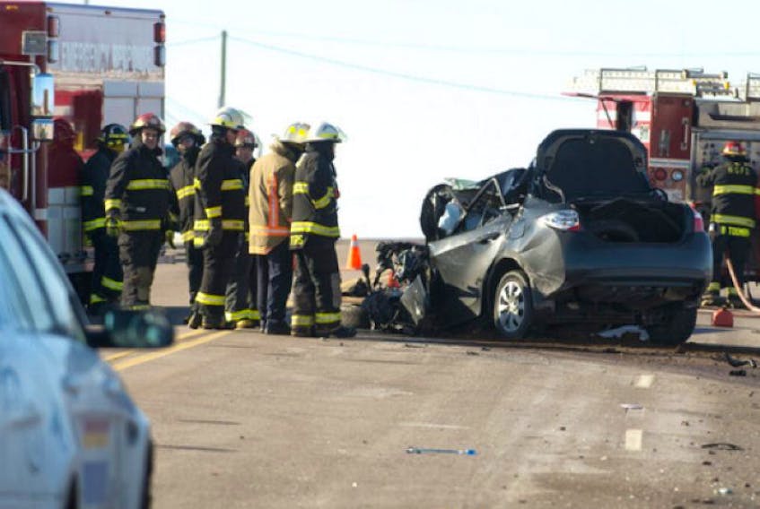 <p><span class="COLOURKicker">Rescue workers examine the wreckage of a car at the scene of a collision Thursday afternoon in Brookfield on Highway 2. A woman died at the scene while the truck driver was transported to the Queen Elizabeth Hospital by Island EMS with undetermined injuries. </span></p>