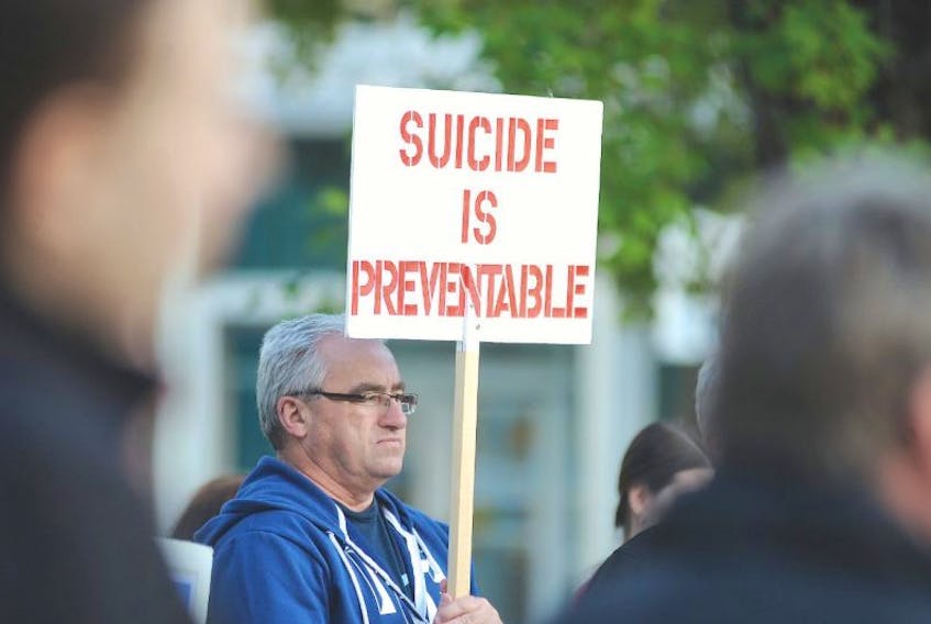 SALTWIRE FILE PHOTO: Bill Griffin holds a sign as he listens to the speakers prior to the start of the World Suicide Prevention Day walk.