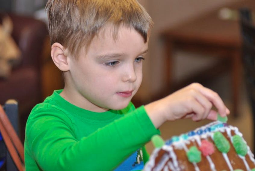 Ryder Borden carefully places a green jelly candy on the gingerbread house he helped build at College of the North Atlantic’s Gingerbread Build in Corner Brook on Saturday.