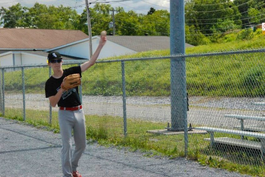 Thomas Hancock loosens up his arm with a soft toss during a Corner Brook Barons Peewee AAA baseball team practice earlier this week at Fred Basha Memorial Park.
