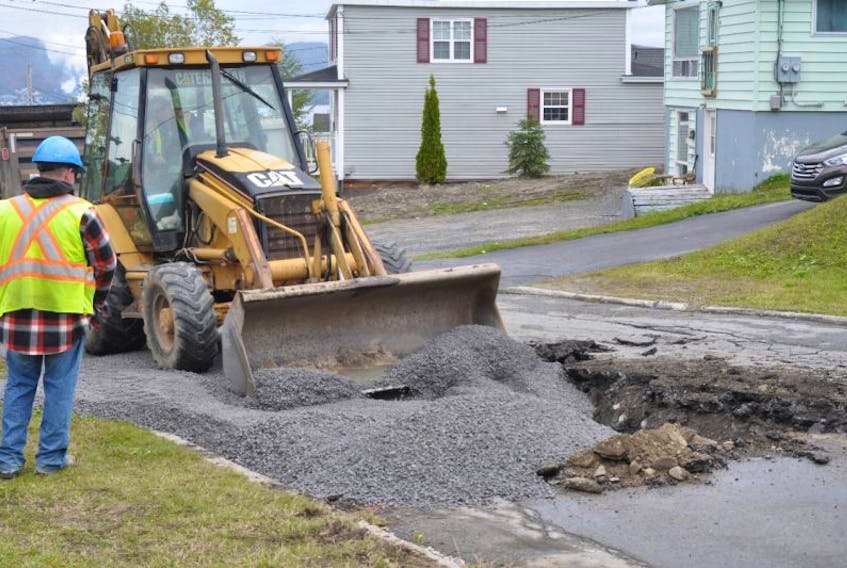 A crew fills a hole on Valley Road as part of the effort to repair a major water line break in Corner Brook Wednesday.