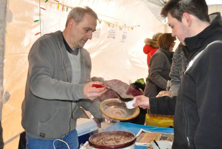 The Western Star's Gary Kean dishes up a sample of his steak and beer chili for Ruben Sheppard at the Western Regional Hospital Foundation's annual carnival chili cookoff in Margaret Bowater Park on Saturday.