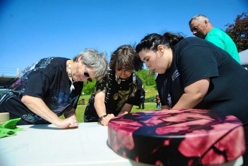 Kristen Pittman, right, facilitated an aboriginal drum-making demonstration during National Aboriginal Day at Margaret Bowater Park in Corner Brook Wednesday morning. Learning the craft were, from left, Dale Osmond and Beatrice Dusome of Jackson’s Arm.