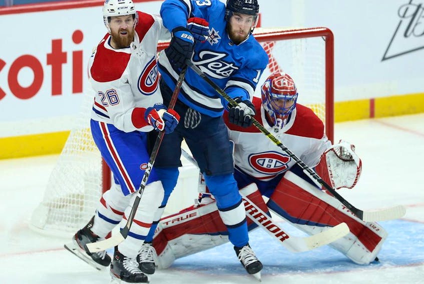 Canadiens defenceman Jeff Petry and Jets centre Pierre-Luc Dubois battle for position in front of goalie Carey Price during game Wednesday night.