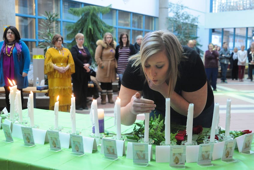 Michelle Branton, executive director of the Community Youth Network in Corner Brook, blows out a candle in memory of one of the 14 women killed in the Montreal Massacre, which happened 28 years ago Wednesday.