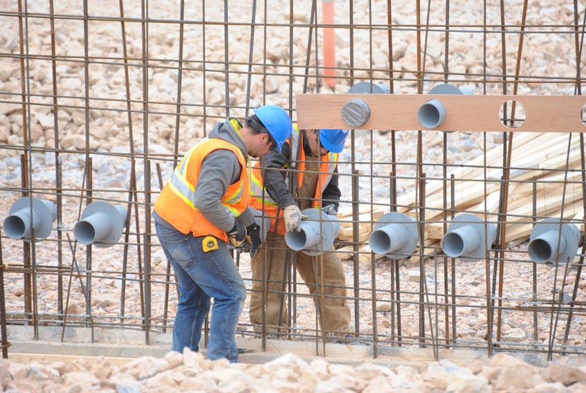 Two workers install some of the mechanical infrastructure for the long-term care building being erected as part of the new regional hospital construction site in Corner Brook during a media tour Thursday.
