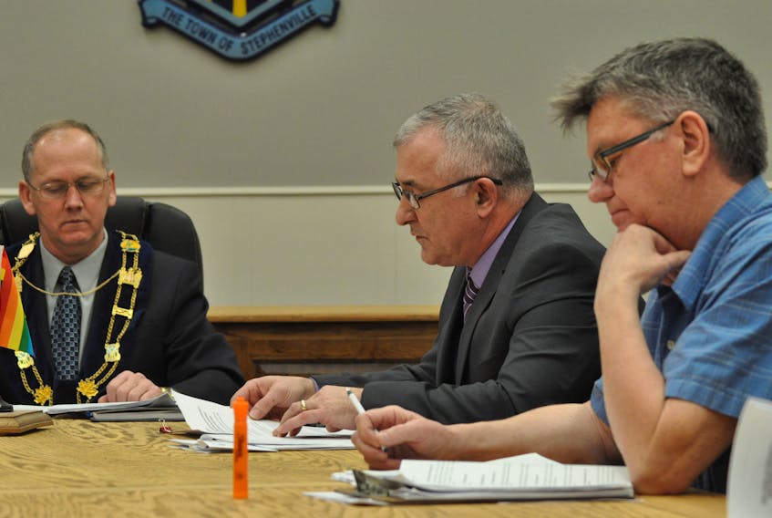 Mayor Tom Rose, left, listens in as Mark Felix, chairman of the Stephenville town council’s finance committee, centre, speaks on his first budget at council’s regular general meeting on Thursday with Coun. Mike Tobin, who voted against the budget, also listening in.
