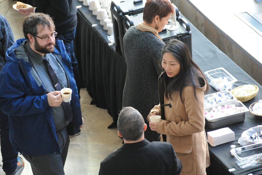 A couple of staffers from the firm Grant Thornton, from left, senior tech analyst Christopher Stone and assurance manager Jadie Zeng, chat with Sean St. George of the Navigate Entrepreneurship Centre during a public coffee break at Grenfell Campus, Memorial University as part of Small Business Week events in Corner Brook Monday.