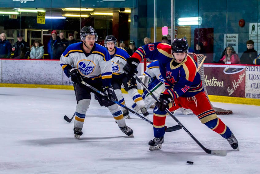 Corner Brook Royals' Ryan Meade, right, carries the puck away from Stephenville Jets' Josh White, as Jets' Jon McCarthy watches in the background during Game 2 of the West Coast Senior Hockey League best-of-five semifinal series Saturday night at the Stephenville Dome.