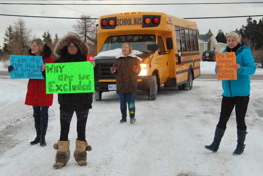 Demonstrators who blocked buses at St. Thomas Aquinas School in Port au Port East on Monday morning are seen marching ahead of one of the buses. They include from left: Phoebe Hoskins, Sabrina Humber, Beverly Hoskins and Bernadette Benoit.