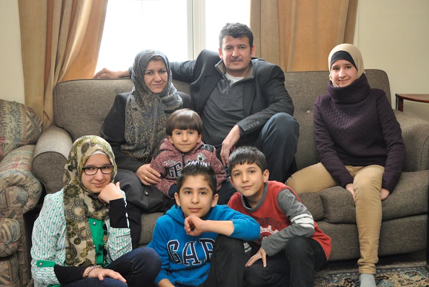 Syrian refugees Mona Haj Mohammed and Fawaz Alshebli have made a home in Corner Brook for themselves and their five children. From left, seated on the couch, are Mona, Malek, Fawaz and Halah; and seated on the floor are, from left, Ayah, Ahmad and Ibrahim.
