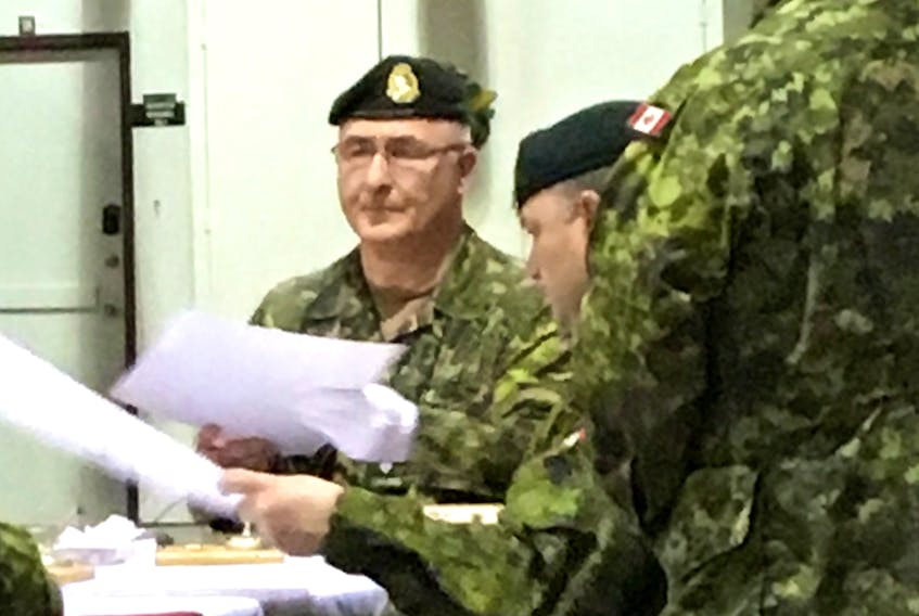 Lt.-Col. Mark Felix, centre, signs the documents required to take over as commanding officer of the Second Battalion of the Royal Newfoundland Regiment at the Gallipoli Armoury in Corner Brook Saturday.