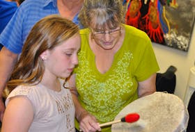 Here, Cora Butt, right, and youth group member Taylor Glover pose for a photo as Butt was demonstrating the proper technique for using the drum to Glover. Glover won a draw after the drum making had ended and was able to take the drum Butt constructed home with her.