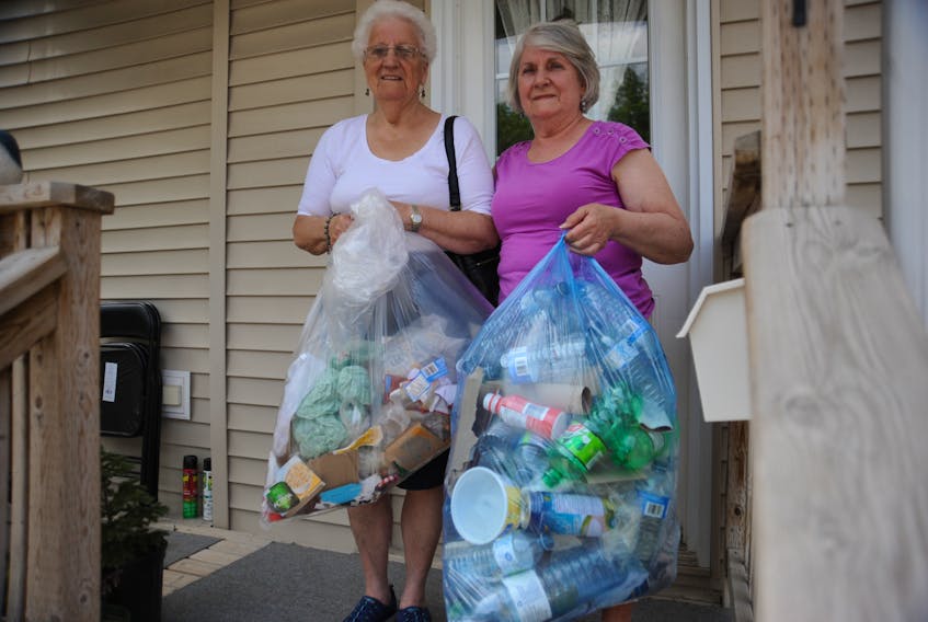 Linda Menchions (left) and her friend Betty Wells of Corner Brook are ready for the new waste collection system hitting parts of western Newfoundland this coming week.
