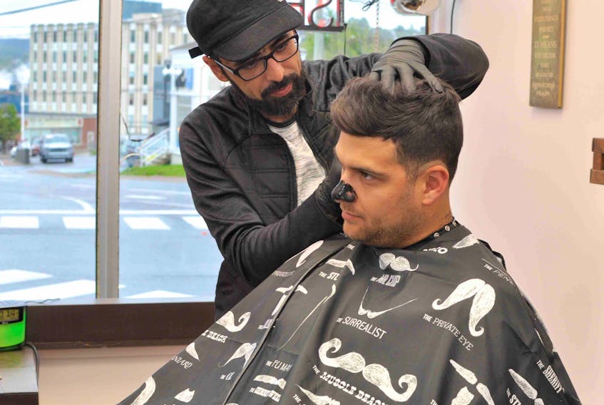 Mohamad Almaidani cuts Stephen Simms' hair at his new barbershop on Broadway in Corner Brook on Monday. Simms has been a customer of Almaidani’s since he started working in the city more than two years ago.