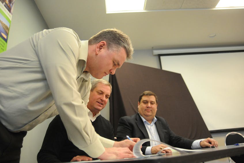 Jonathan Sharpe, left, a senior biologist with the provincial government, signs as a witness to the Municipal Habitat Stewardship Agreement signed Monday by, from left, Fisheries and Land Resources Minister Gerry Byrne on behalf of the provincial government and Mayor Jim Parsons on behalf of the City of Corner Brook.