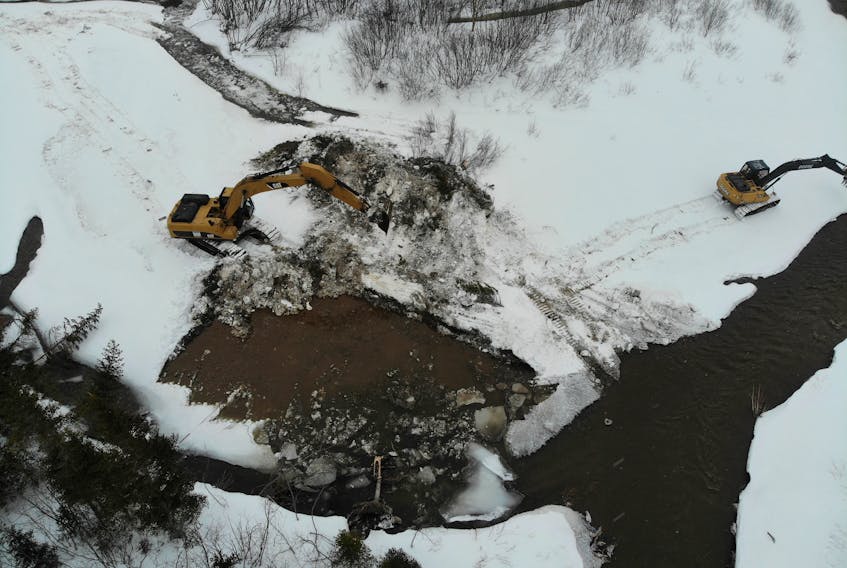This aerial view taken by a drone on Tuesday shows two excavators working at rerouting Cold Brook back to its original course following flooding in the community named after the brook on the weekend.
