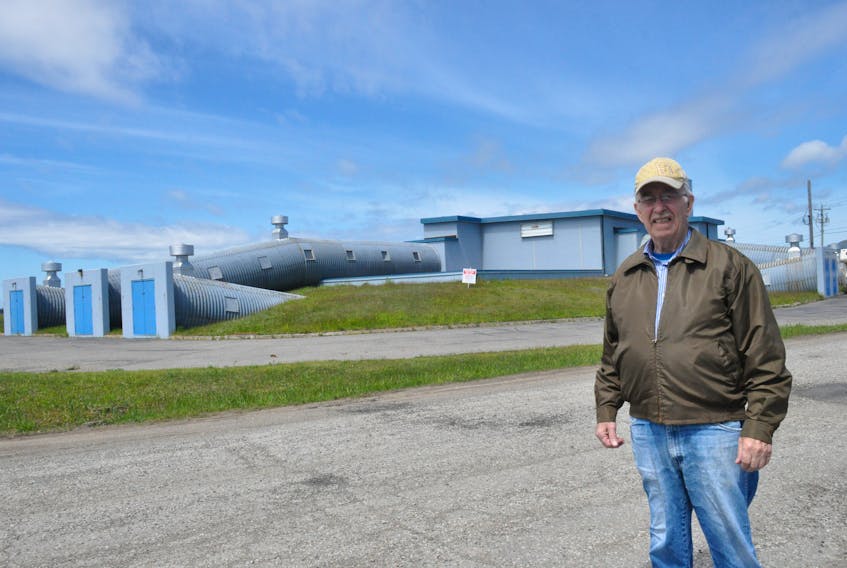 Bill Pilgrim, a former worker on the Ernest Harmon Air Force Base, poses for a photo near the Mole Hole building.