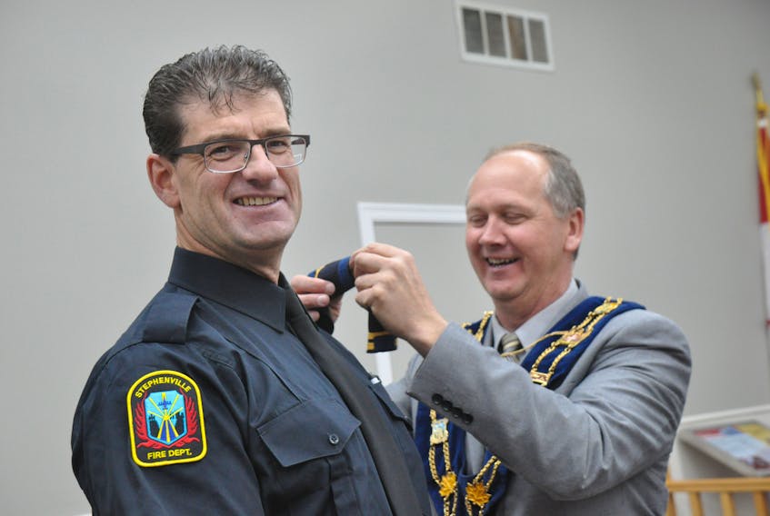 Mayor Tom Rose, right, applies a shoulder captain's epaulette on the shirt of Tony Pottle, a 26-year career firefighter with the Stephenville Fire Department, on Thursday. Pottle went up in rank following a rigorous competition for the captain's stripes that involved four members of the department.