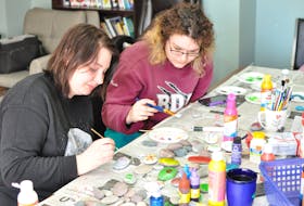 Tamara Young, left, and Rosie Hoskins helped paint rocks in honour of Rehtaeh Parsons at the Corner Brook Women's Centre on Wednesday morning. The rocks will be placed along the route of a memorial walk for the Nova Scotia teen taking place in Corner Brook on Saturday.
