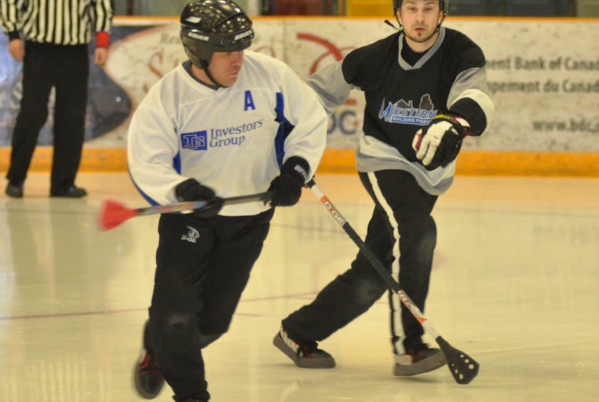 Investors Group's Johnny Pelley, left, moves toward the ball while being watched by Western Building Products' Paul Prosper during Game 2 of the Corner Brook Molson Men's Broomball League best-of-five final at the Corner Brook Civic Centre in this March 26 file photo.