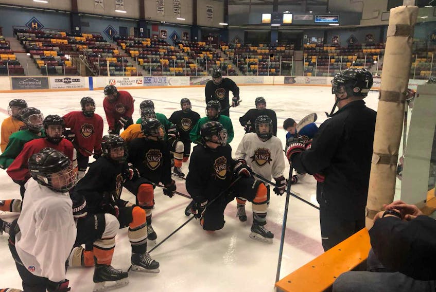 Head coach Mark Robinson, right, speaks with members of the provincial major midget hockey league's Western Kings during a team practice Wednesday night at the Corner Brook Civic Centre.