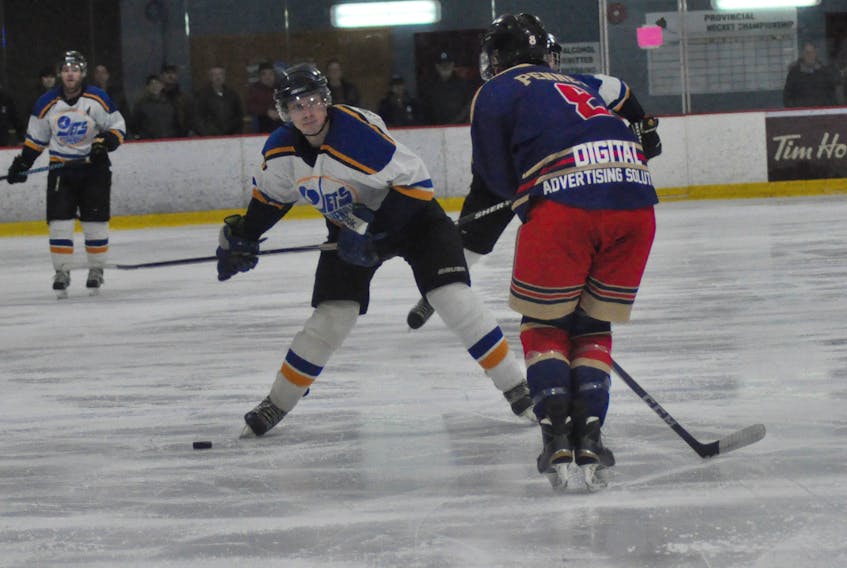 With Jamie Penney, right, of the Corner Brook Royals in a blocking position, Jonas Foley of the Stephenville Jets winds up for a slap shot on Saturday evening.