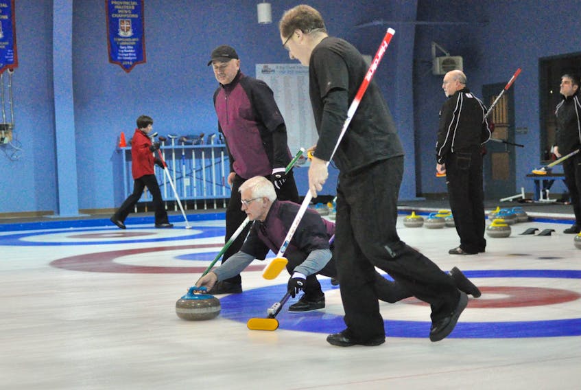Team Oke’s Blair Fradsham releases the stone while Mike Mullins, back, and Dennis Bruce get ready to sweep it towards the house during opening day action at the 2019 senior curling provincial championships at the Corner Brook Curling Club.