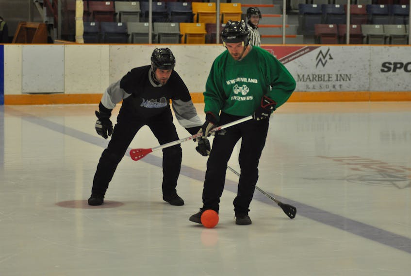 Newfoundland Fasteners’ Chris Bulger (right) protects the ball from Western Building Products’ Lance Ereaut during Corner Brook Molson Men’s Broomball League play Monday night at the civic centre.