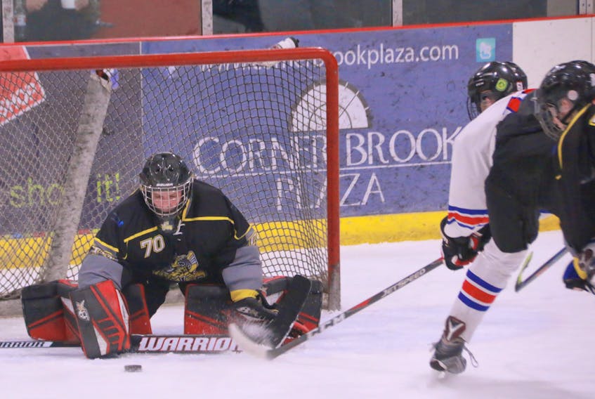 Corner Brook Regional High Titans goalie Keegan Deering kept his stick close to the ice to stop the puck with Elwood High Lakers’ Drew Langdon looking for a rebound during high school hockey league action Monday night at the Hodder Memorial Recreation Complex.