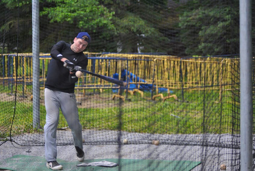 Corner Brook Barons' Anderson Traverse puts some work in inside the batting cage at Jubilee Field during a team practice on Thursday night.