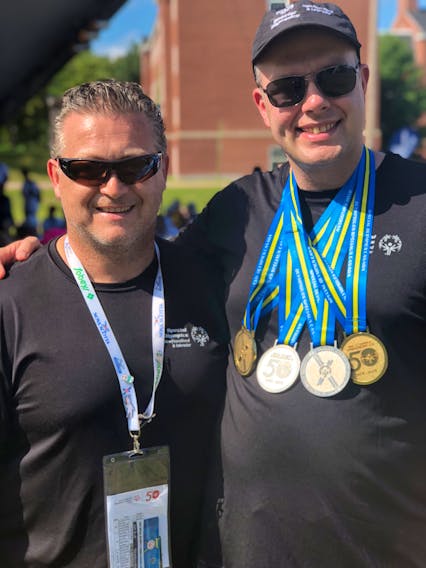 Daniel Moores, right, and his coach Jeff Butt after Daniel received his powerlifting medals from the 2018 Special Olympics Canada Summer Games in Antigonish, N.S.