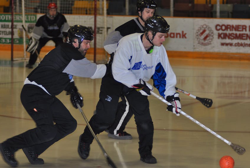 Investors Group's Scott Wayson, right, attempts to control the ball while being marked by Western Building Products' Lance Ereaut, left, and Paul Prosper during Game 1 of the best-of-five Corner Brook Molson Men's Broomball League final on Monday night at the Corner Brook Civic Centre.