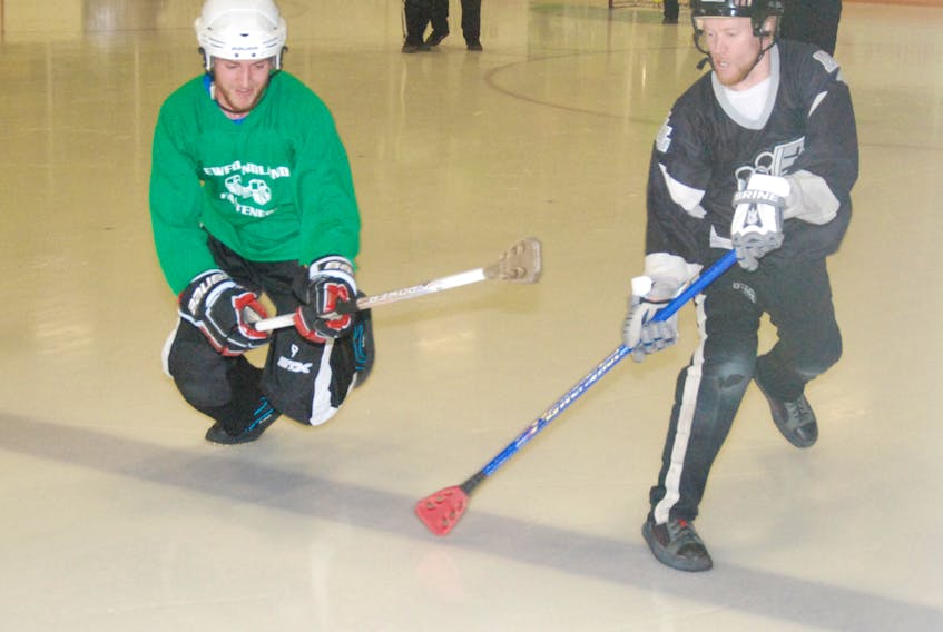 Western Building Products' Mike Hawco, right, and Newfoundland Fasteners' Nate English go for a loose ball during Corner Brook Molson Men's Broomball League playoff action on Monday night at the Corner Brook Civic Centre.