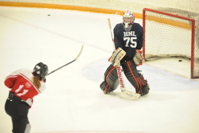 Corner Brook U16 goaltender Jessica Park gets a block on a puck shot by teammate Makaila Austin during a team practice Wednesday evening at the Kinsmen Arena II.