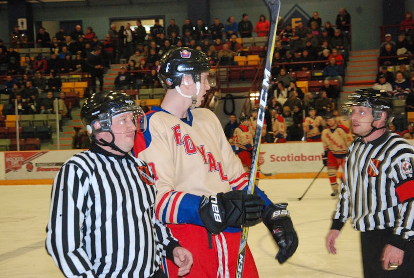 Adam Loveless of the Corner Brook Royals has a discussion with referee Tony Baird after being assessed a minor penalty during a recent West Coast Senior Hockey League game against the Port aux Basques Mariners. Linesman Dean McCarthy is seen here directing the lanky defenceman to the penalty box.