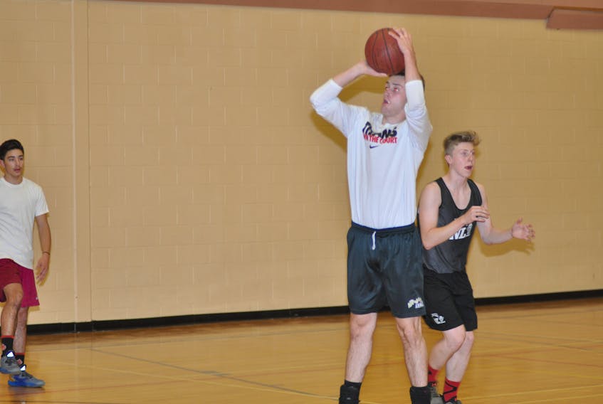 In this file photo, Dawson Greene (centre) gets ready to take his shot, while Noah LaCour-Thistle waits for a pass behind him during a passing/shooting drill at a Corner Brook Regional High Titans basketball practice earlier this season.
