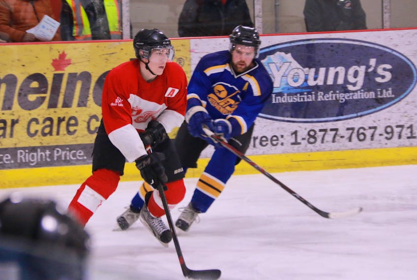 Luke Parsons of the Deer Lake Red Wings is watched closely by Stephenville Jets defenceman Cam Dohaney during a recent West Coast Senior Hockey League game at the Hodder Memorial Recreation Complex in Deer Lake.