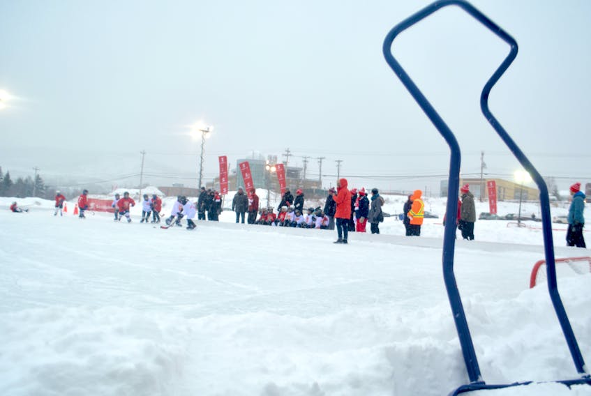 A group of young players work for possession of the puck during an outdoor game during Hockey Day in Canada at the Corner Brook Civic Centre.