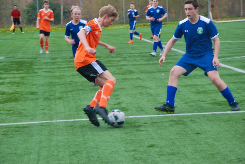Keegan Piercey of the Western Wolves is closed watchly by two Paradise players during the second game of a three-game series to start the 2018 provincial 15U male soccer league season Saturday afternoon at Wellington Street Sports Complex in Corner Brook.
