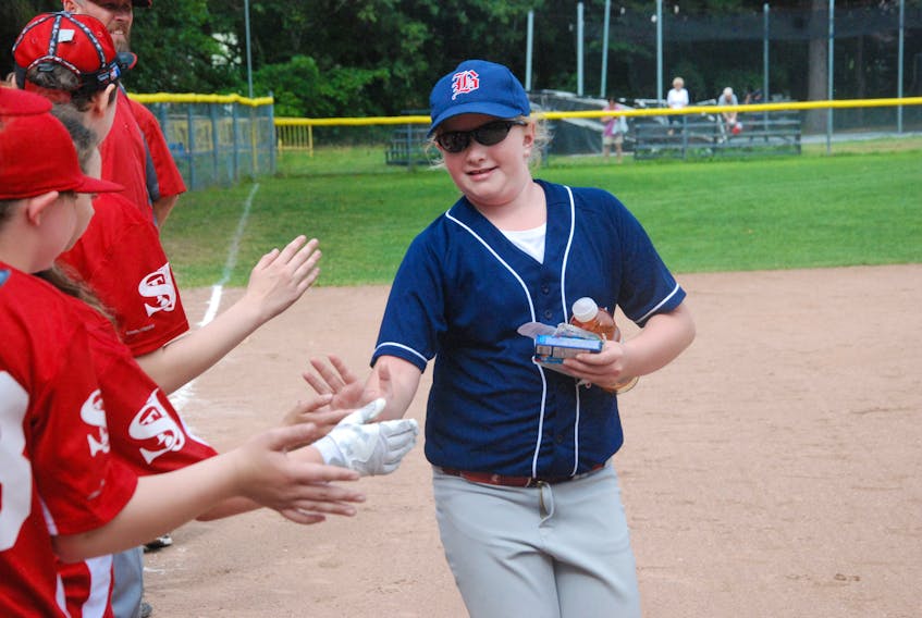 Lauren Pike of the Corner Brook Barons 12U AA female baseball team receives congratulations from members of the St. John's Capitals after winning player of the game honours in a big win for the home side in double-round robin play Saturday at Little Jubilee Field. Pike won the tournament's top batter award after her team captured the silver medal.